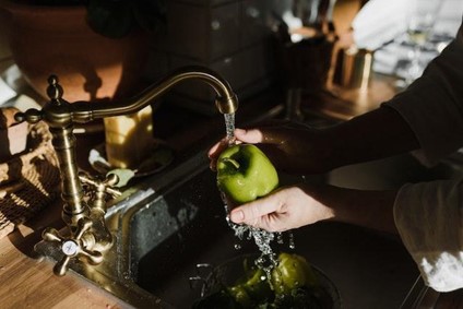 This step tends to be forgotten quickly, but it means the world has hot water and electricity when you move into your new home. Running water from a tap and a set of hands washing a green apple.