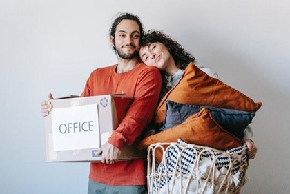 Classifying your boxes will make the tasks easier for everyone included in this process. A couple hugging with a basket of pillows and a labelled box while making their long-distance move easier.